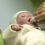 A newborn&#39;s mouth is cleaned