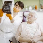 A dentist discusses gum transplant surgery with a patient.